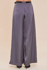 Pantalón palazzo de pierna ancha color gris, con acabado satinado y cinturón negro.