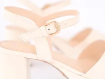 Sandalias color crema con plataforma, tacón cuadrado y tira en el tobillo con hebilla.
