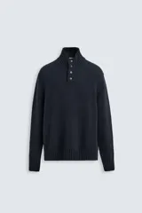 Jersey azul marino de punto con mezcla de algodón y lana. Tiene cuello alto con cierre de botones y manga larga.