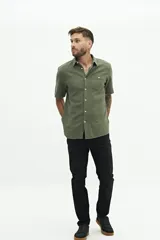 Camisa de manga corta color verde oliva, con textura tipo crepé y fit regular.