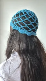 Gorro tipo cofia de crochet color celeste, con diseño de red y borde ondulado.