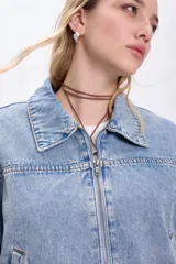 Campera de jean celeste, corte cropped, con cuello clásico, cierre frontal con cremallera, mangas largas con puños elásticos y bolsillos laterales.
