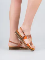 Sandalia con plataforma baja, tiras con estampado de piel de serpiente y detalles metálicos.