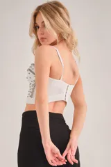 Corset blanco con detalles de pedrería plateada, tiras removibles y espalda ajustable.