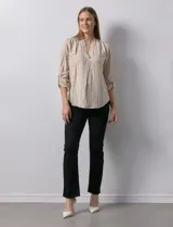 Blusa beige con rayas verticales blancas, escote en V y mangas 3/4 regulables con presilla y botón.