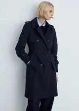 Trench coat azul marino con doble botonadura, cinturón ajustable, cuello de solapa, trabillas en los puños y abertura posterior en el bajo.