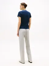 Chomba azul marino de corte slim, confeccionada en algodón elástico. Tiene cuello y mangas ribeteados en blanco, tapeta de cinco botones y logo bordado en el pecho.