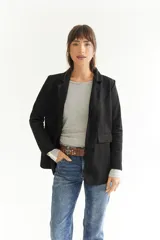 Blazer azul marino de tela agamusada, corte clásico, con solapas y bolsillos frontales.