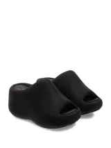 Sandalia negra tipo zueco con suela gruesa, forrada en tela y diseño cómodo.