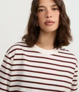 Remera de algodón color blanco con rayas horizontales color marrón, de corte amplio, cuello redondo y mangas cortas.