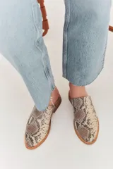 Zapatillas de charol negro con decoración de perlas, diseño abierto en la parte trasera.