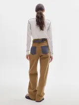 Pantalón de denim color marrón claro, de tiro alto, corte amplio y pinzas en la cintura.