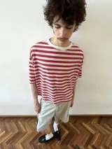 Remera de manga corta con cuello redondo, confeccionada en viscosa, con un patrón de rayas horizontales rojas y blancas.