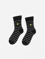 Par de medias negras con rayas horizontales blancas y un smiley face amarillo a la altura del tobillo.