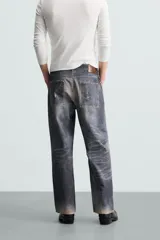 Pantalón de jean azul con lavado gastado, corte holgado y cinco bolsillos.