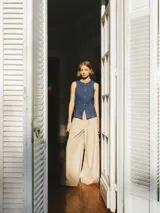 Pantalón oversize de pierna ancha color beige, con pliegues y bolsillos laterales.