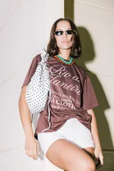 Bolso tipo cartera de nylon con diseño plisado y estampado abstracto en tonos claros.