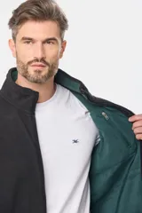 Campera de abrigo negra confeccionada en polar con interior combinado en verde. Cuenta con cierre frontal, cuello alto, bolsillos laterales, bolsillo en el pecho y bolsillos de seguridad internos con cierre.