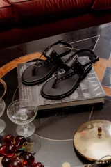 Sandalias negras de cuero con tiras finas y microtachas plateadas.