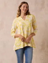Blusa amarilla con estampado floral blanco, escote en V y mangas 3/4.