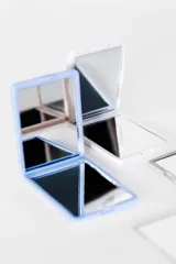 Espejo compacto en mezcla de colores, ideal para llevar en el bolso.