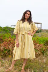 Vestido túnica a rayas verticales color mostaza y blanco, con cuello redondo, mangas cortas abullonadas y lazo para atar en la cintura.