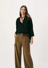 Camisa negra de corte holgado, con cuello clásico, cierre frontal con botones y mangas 3/4.