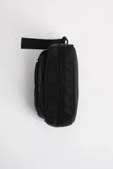 Necesser rectangular negro de tela impermeable con dos compartimentos con cierre y correa de mano.
