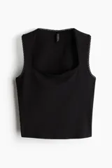 Musculosa negra de punto con escote cuadrado y ribete de picot en cuello y sisas.