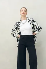 Pantalón de jean azul oscuro, de corte ancho y tiro alto, con bolsillos delanteros cuadrados y amplios.