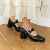Zapato Mary Jane de cuero vacuno negro con textura tipo cocodrilo, punta cuadrada, tira sobre el empeine con hebilla metálica y tacón cuadrado.