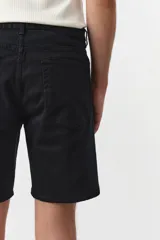 Short negro de sarga de algodón suave, corte estándar y cinco bolsillos con cierre y botón.