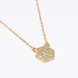 Collar dorado con cadena fina y dije hexagonal con incrustaciones de strass.