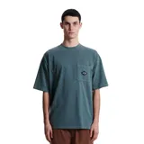 Remera de algodón color verde azulado con efecto lavado, corte holgado y bolsillo frontal con un pequeño bordado en forma de diamante.