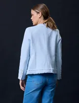 Chaqueta de tweed color beige, marca Nanette. Tiene cuello a la base, abertura central, bolsillos delanteros, puños con botones perlados, terminación desflecada y forro interno.