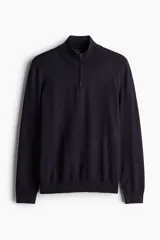 Buzo de punto fino azul marino con cuello alto acanalado y medio cierre. Corte ajustado.