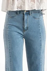 Jean de mezclilla azul claro, tiro medio, corte recto con leve campana al tobillo. Presenta costuras verticales marcadas en el frente y en los laterales de las piernas, y terminación deshilachada en el ruedo.