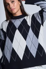 Sweater de punto con diseño de rombos en tonos beige y blanco, cuello redondo y corte holgado.