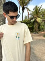 Remera beige de algodón con estampa en la espalda de una flor sonriente sobre un fondo a cuadros azules y texto "FLOWKERS".