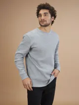 Remera de manga larga gris, confeccionada en tejido waffle.