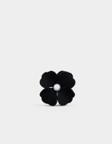 Broche negro con forma de flor y aplique de strass en el centro.