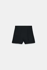 Shorts de tiro alto color negro, con pinzas en delantero y espalda. Cierre trasero con cremallera metálica a contraste.