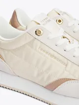 Zapatillas Tommy Hilfiger color crema con detalles en beige y dorado. Confeccionadas en poliéster con paneles mixtos y logo bordado en la lengüeta y el talón.