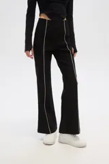 Pantalón negro de viscosa, corte ajustado y cintura alta, con línea vertical blanca a lo largo de la pierna.