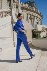 Pantalón palazzo de seda color azul eléctrico, tiro alto, con bolsillos laterales y traseros simulados. Cierre frontal con botón y cremallera.