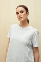 Remera blanca de algodón liviano con textura sutil, manga corta y cuello redondo.