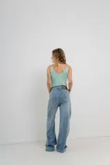Pantalón de jean azul de tiro alto y corte wide leg, con detalle de parche animal print en la parte trasera.