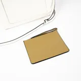 Cartera tipo tote de cuero sintético color blanco con bolsillo externo marrón con cierre. Tiene doble asa de mano y correa larga desmontable y regulable.