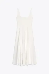 Vestido midi blanco de Zara Woman Collection, con escote cuadrado y sin mangas. Corte al cuerpo con falda evasé. Cierre con cremallera oculta en la costura.