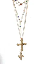 Collar dorado de múltiples cadenas con dijes de cruces ornamentales con incrustaciones de cristales multicolores.